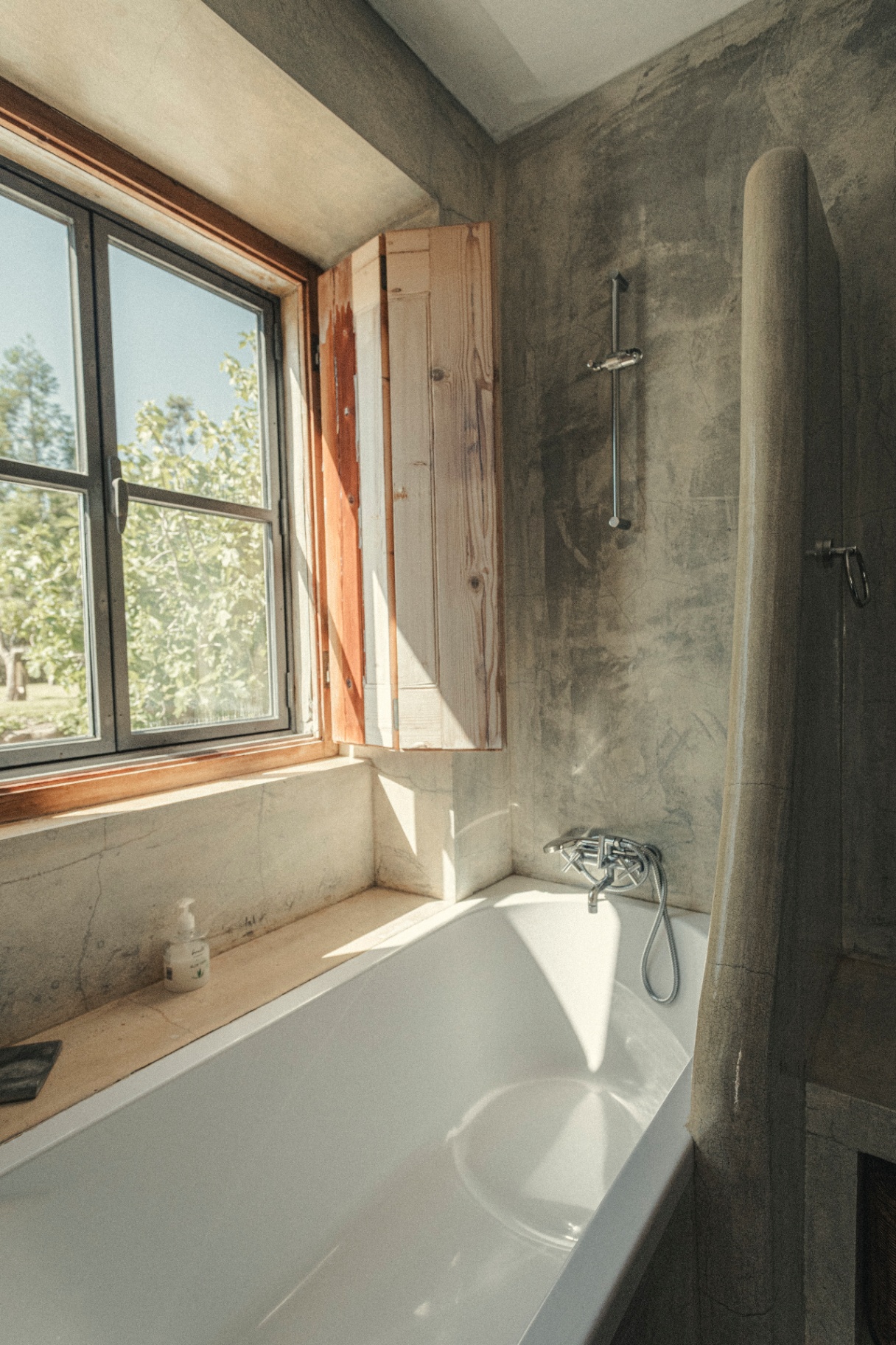 Concrete bathroom with wooden shutters and garden light
