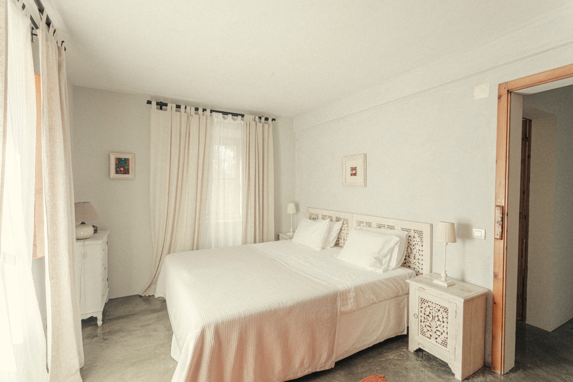 White bedroom with carved headboard