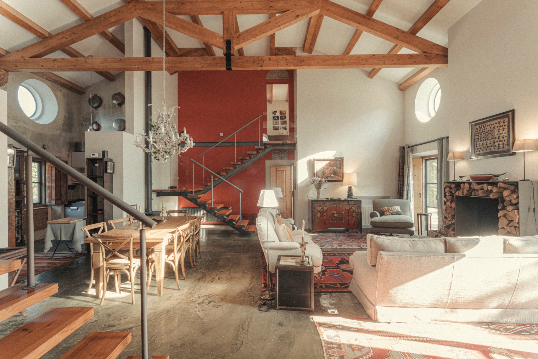 Open plan living and dining room beneath exposed roof trusses