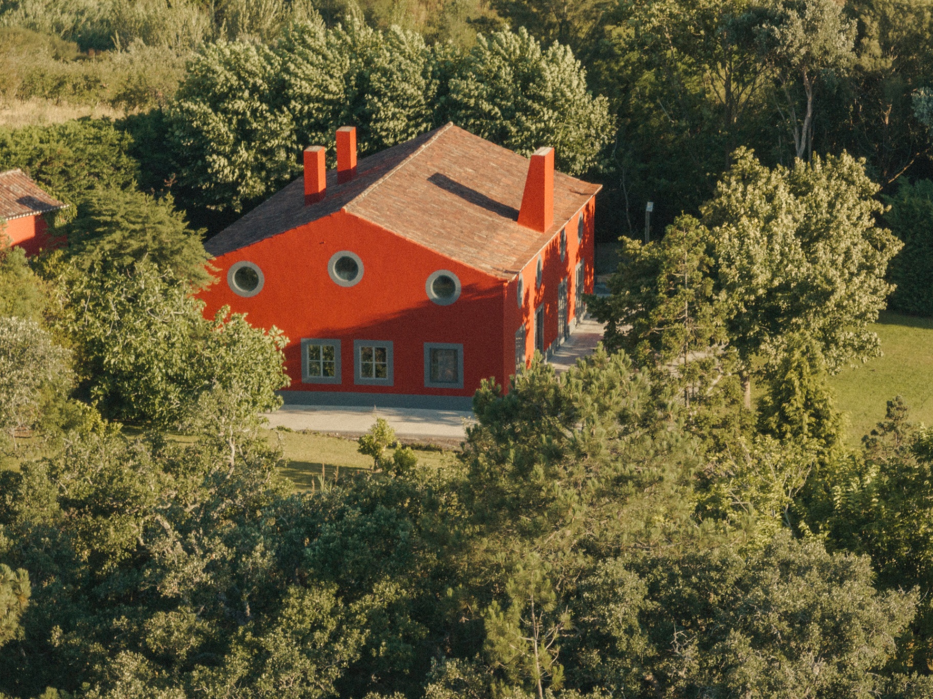 The red facade rising from the trees
