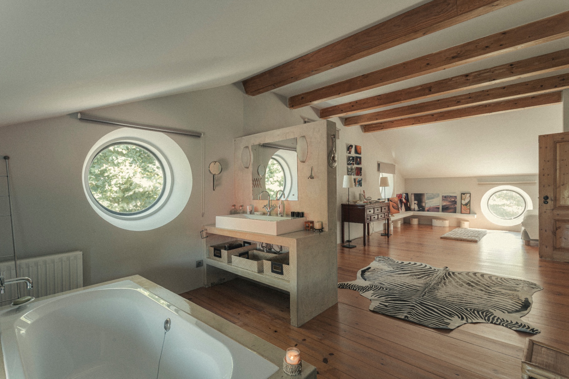 Master suite with concrete bath and round windows