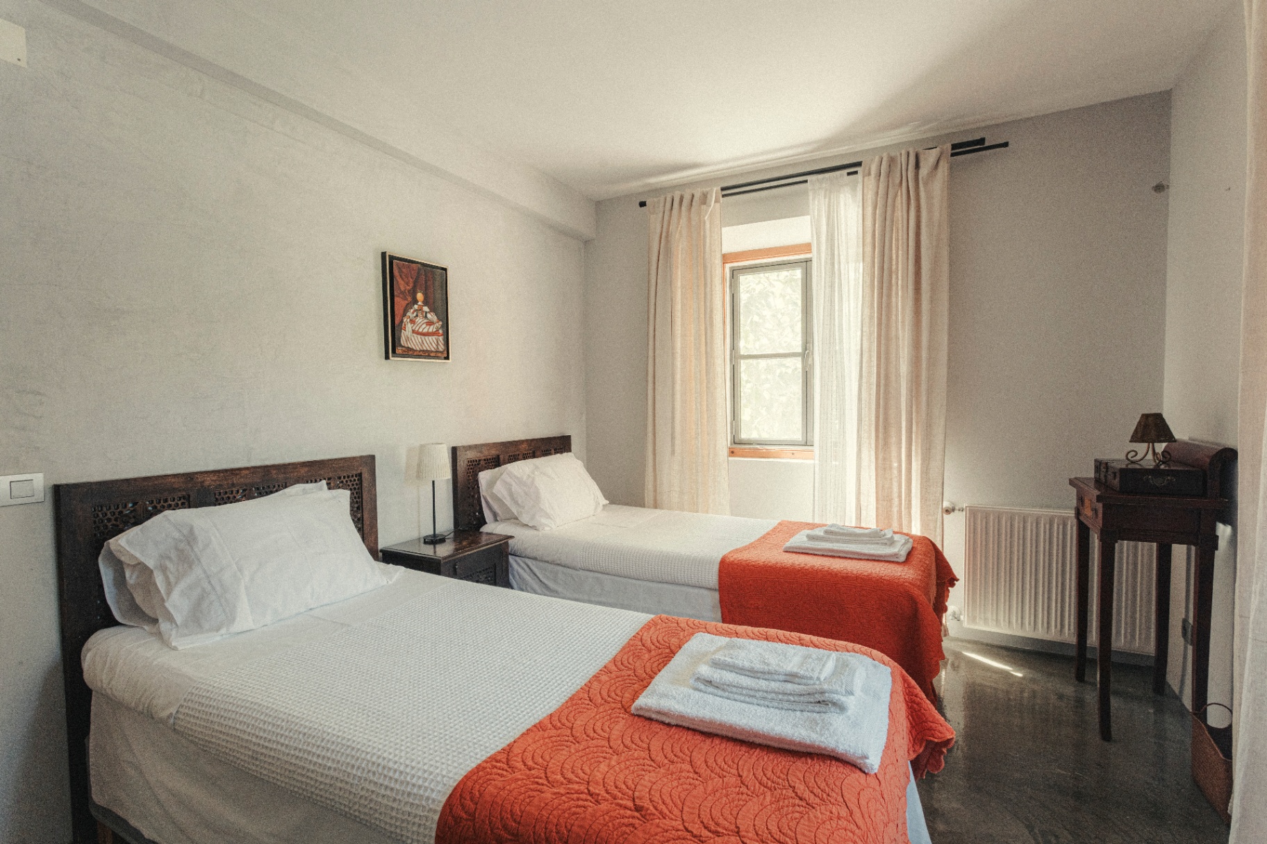 Twin bedroom with terracotta throws and carved headboards