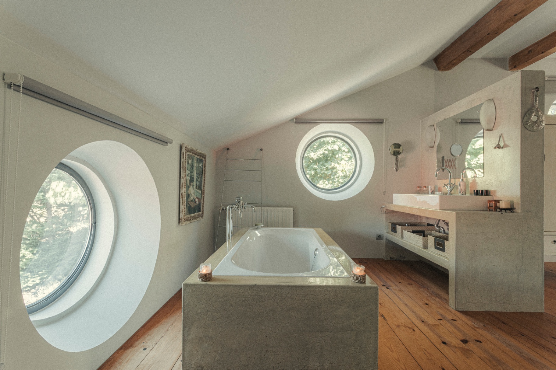 Bathroom with twin porthole windows and concrete tub